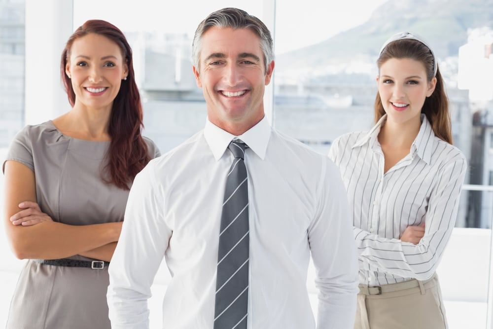 Smiling businessman with his co-workers in an office