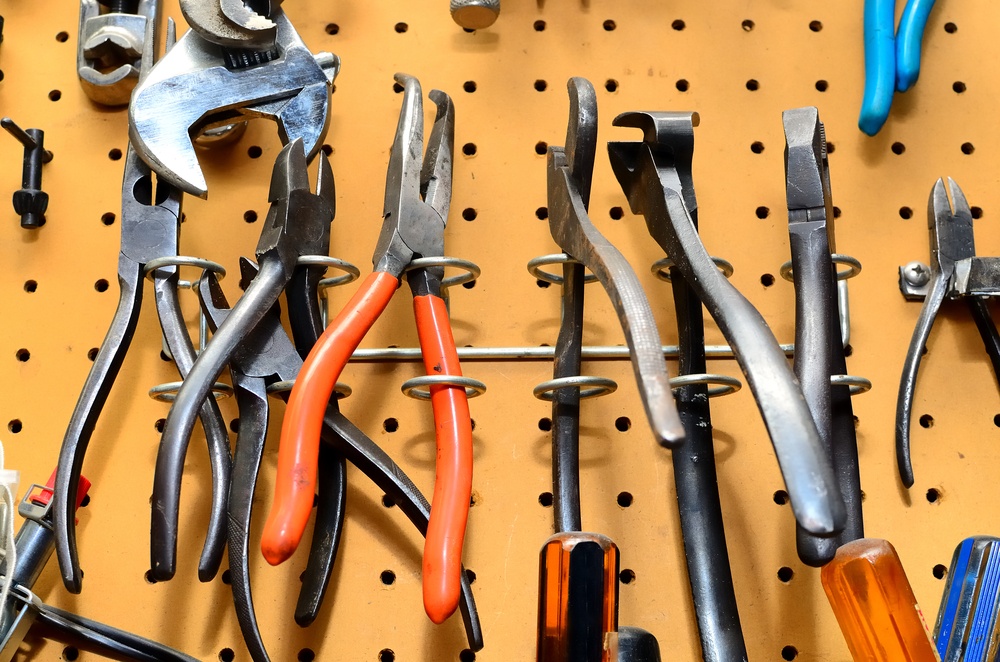 different plyers on a workshop wall.